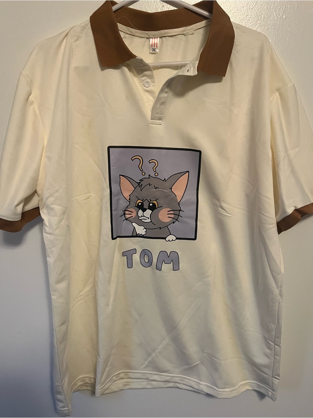 Cream Polo Shirt with Brown Collar and Tom Graphic